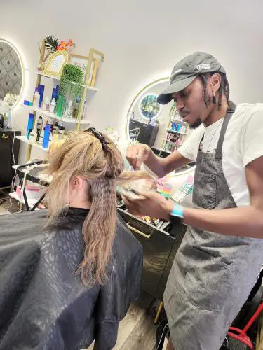 A hairstylist cutting a client's hair in a modern salon.