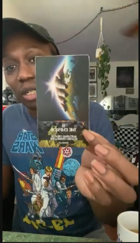 Person holding a Star Wars VHS tape in a room.