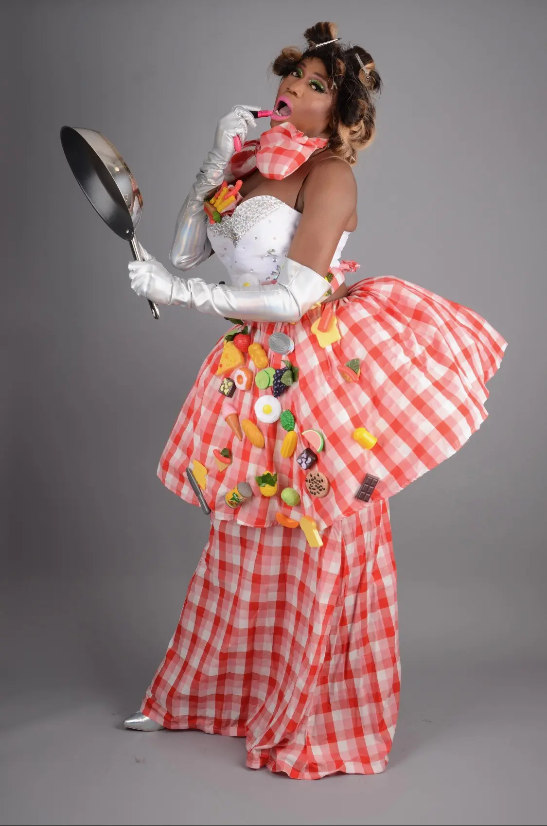Elegant model in a pink gingham dress with floral details and white gloves.