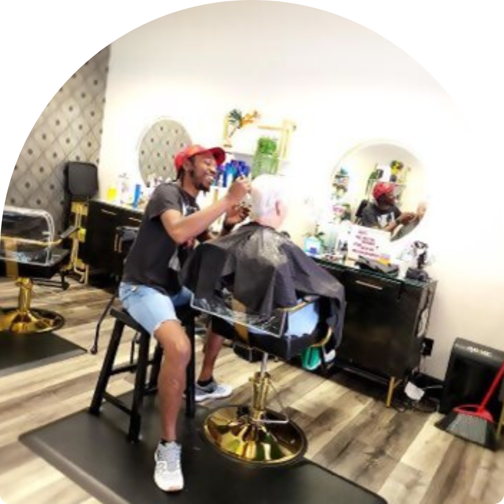 A barber giving a haircut inside a stylish barbershop.