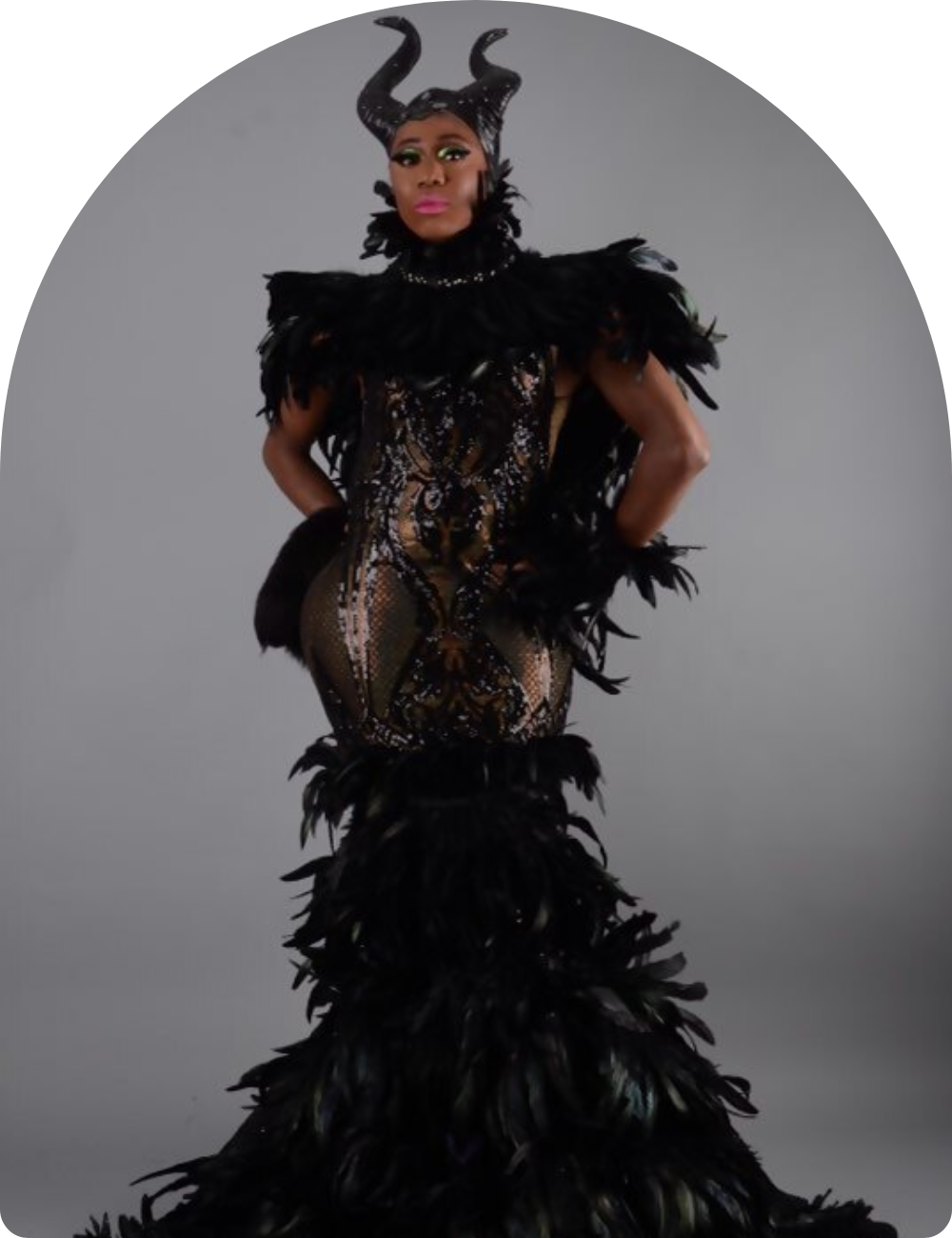 Model in a dramatic black feathered and corseted gown.