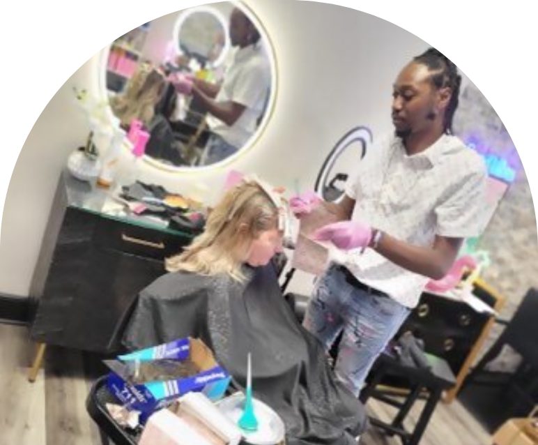 Hair stylist blow-drying a client's hair in a salon.