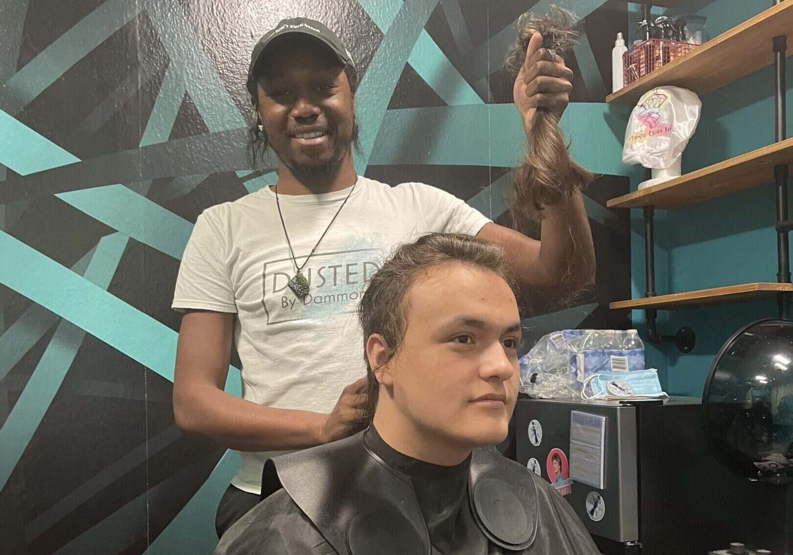A man gets a haircut from a barber in a stylish barbershop.